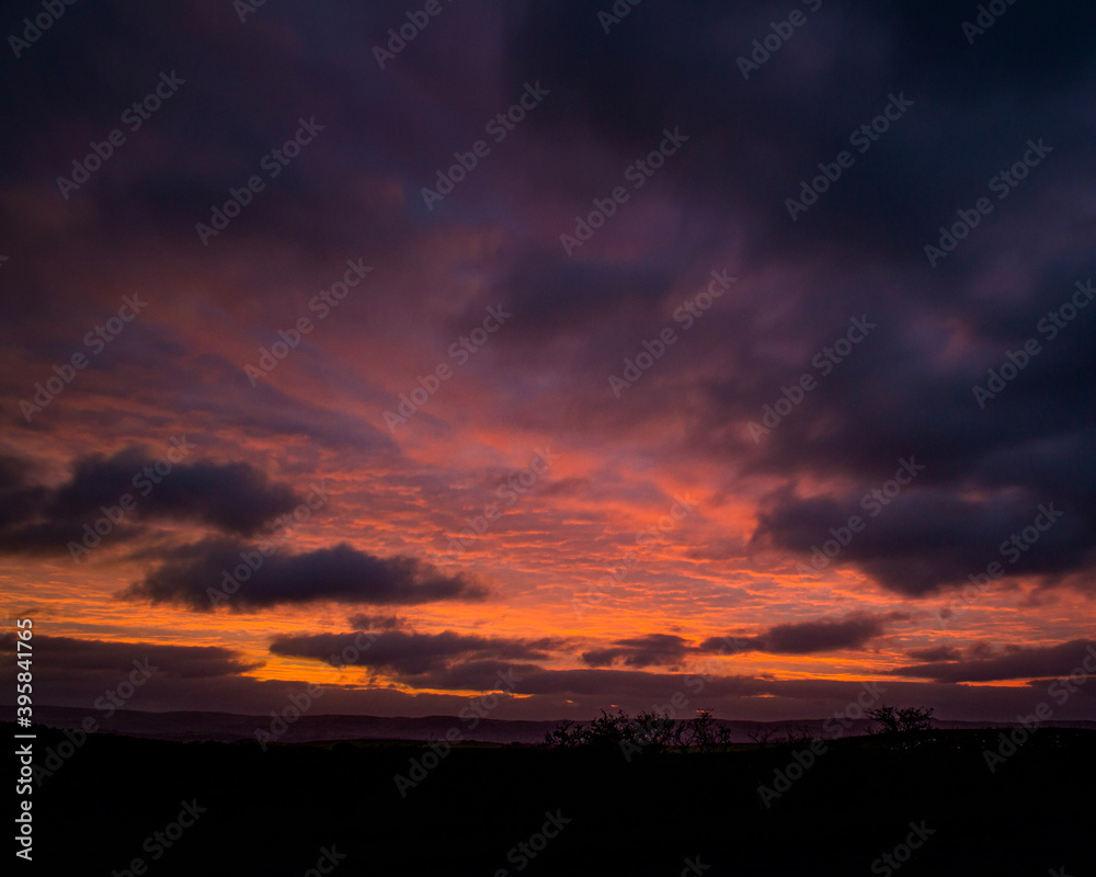 red sunset sky in a rural setting in wales vibrant orange and clouds 