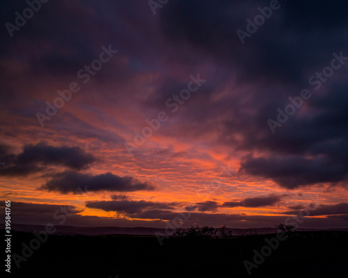 red sunset sky in a rural setting in wales vibrant orange and clouds 