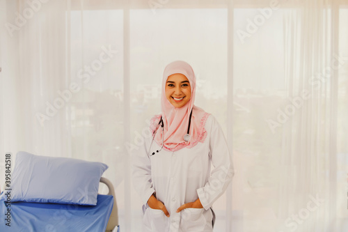 Portrait of a friendly charming Muslim woman in a white hijab, smiling, healthy in a hospital ward.
 photo