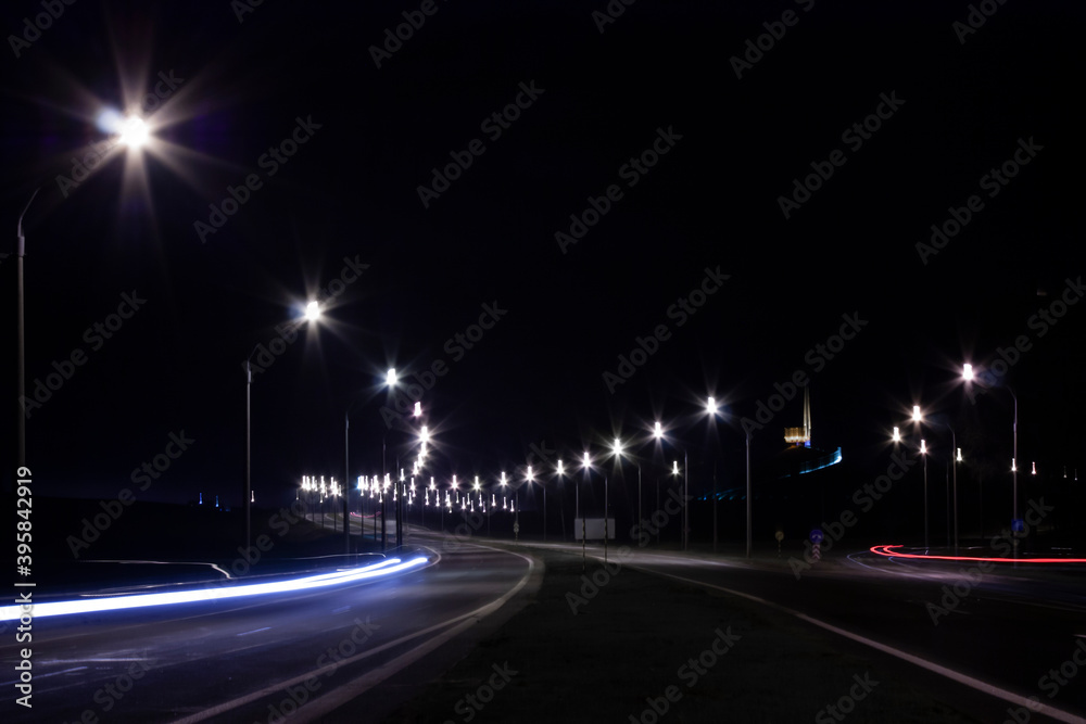 Horizontal landscape photo of a highway at night lighting with street lamps along it Horizontal landscape photo of a highway at night lighting with street lamps along it