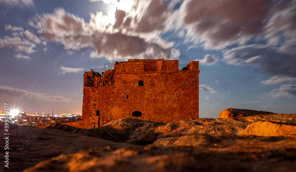 Obraz premium Medieval castle on the shores of the Mediterranean Sea in Paphos city on the island of Cyprus in the light of the full moon.