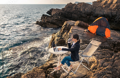 Business woman working from the beach. Working from distance concept. Freelancer travel and work online.