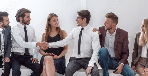 young business people shaking hands while sitting in the office lobby photo
