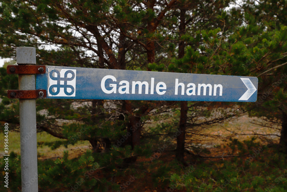 Sign post with direction to the old medievial harbor, Gamle hamn, located at the Faro island in the Swedish province of Gotland.