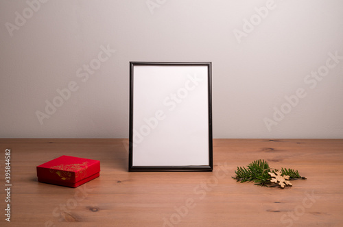 Empty frame, christmas tree twig and small gift photo