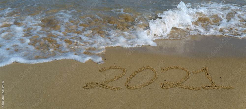 Fototapeta premium Happy new year 2021 written in the sand.Happy new year 2021 written in the sand by the sea.
