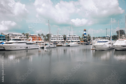 Luxury yachts and private boats moored at pier in the seaport. In bacgroung the light cloudy sky photo