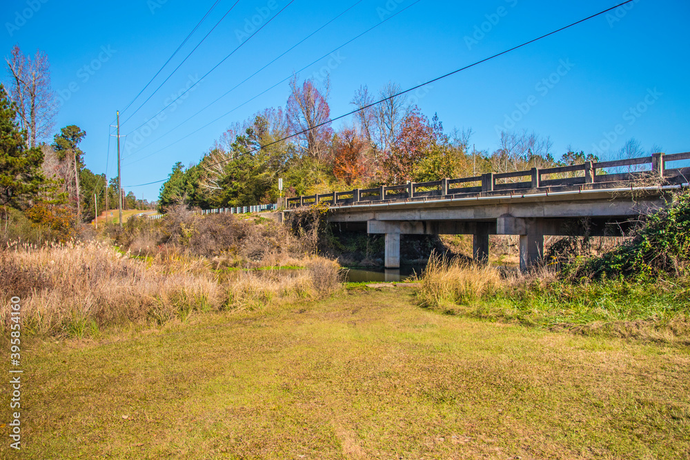 A river stream under a bridge and tire tracks in the south on a clear sunny day A river stream under a bridge and tire tracks in the south on a clear sunny day