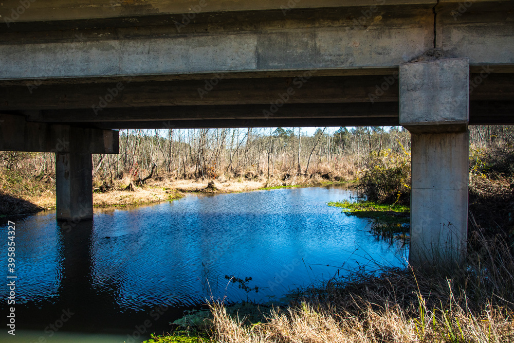Naklejka premium A river stream under a bridge in the south