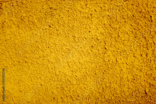 Yellow wall with plaster textured finish. Bright color paint background on backdrop