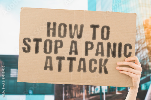 The phrase " How to stop a panic attack " on a banner in men's hand with blurred background. Psychology. Crazy. Anxiety. Fear. Healthcare. Problem. Hospital. Desperate © AndriiKoval