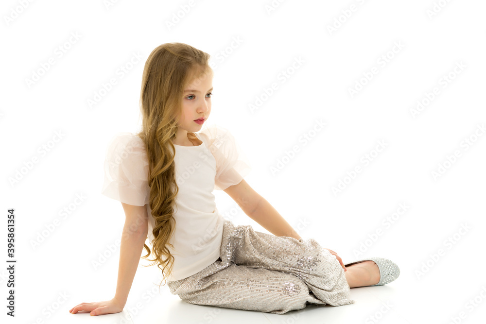Little girl is sitting on the floor.The concept of a happy child Little girl is sitting on the floor.The concept of a happy child