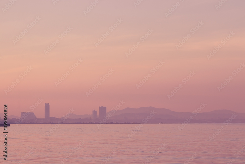 Beautiful seascape view of Skyline and mountain hill in twilight time of sunrise at Pattaya City, Chonburi, Thailand.