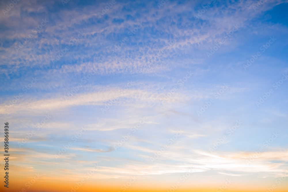 Fototapeta premium Blue sky with white and yellow clouds at sunset background