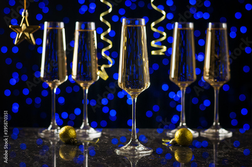 Serpentine and five glasses of sparkling wine on a blue bokeh background.
