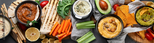 Different kinds of hummus dips with snacks