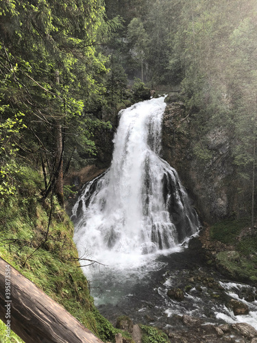 the most beautiful waterfall among the trees in the forest in austria photo