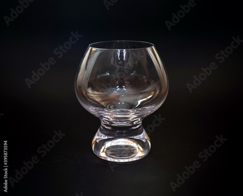 Glass shaped transparent wine glass close up on black background