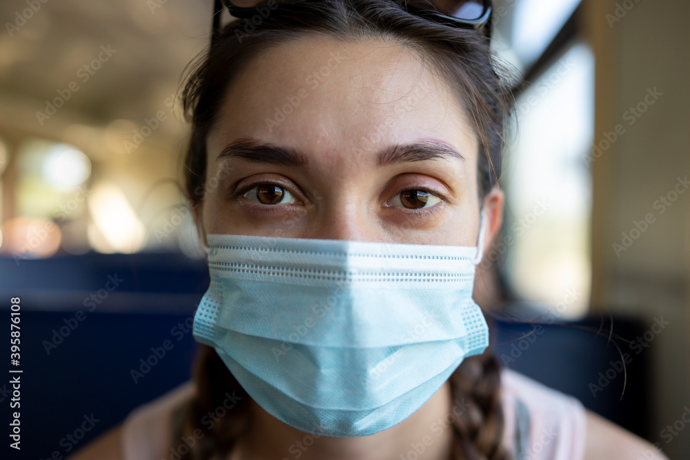 A girl in a protective mask in a subway car. A girl in a protective mask in a subway car.