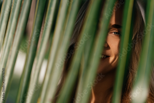 portrait of tender woman looking out of palm leaf Bali Indonesia