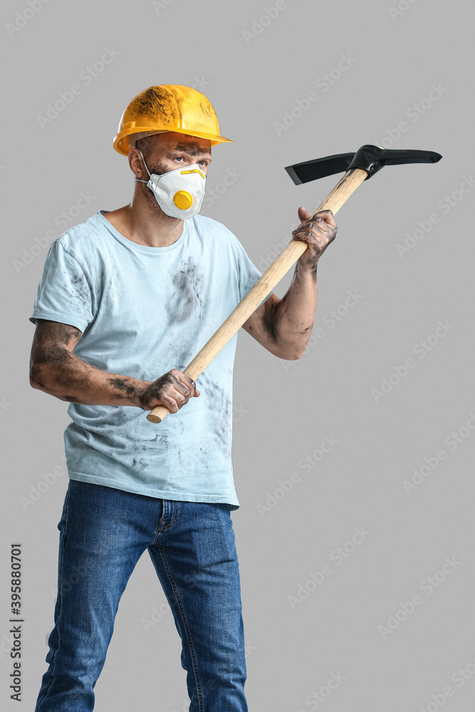 Miner man with pick axe on grey background Miner man with pick axe on grey background
