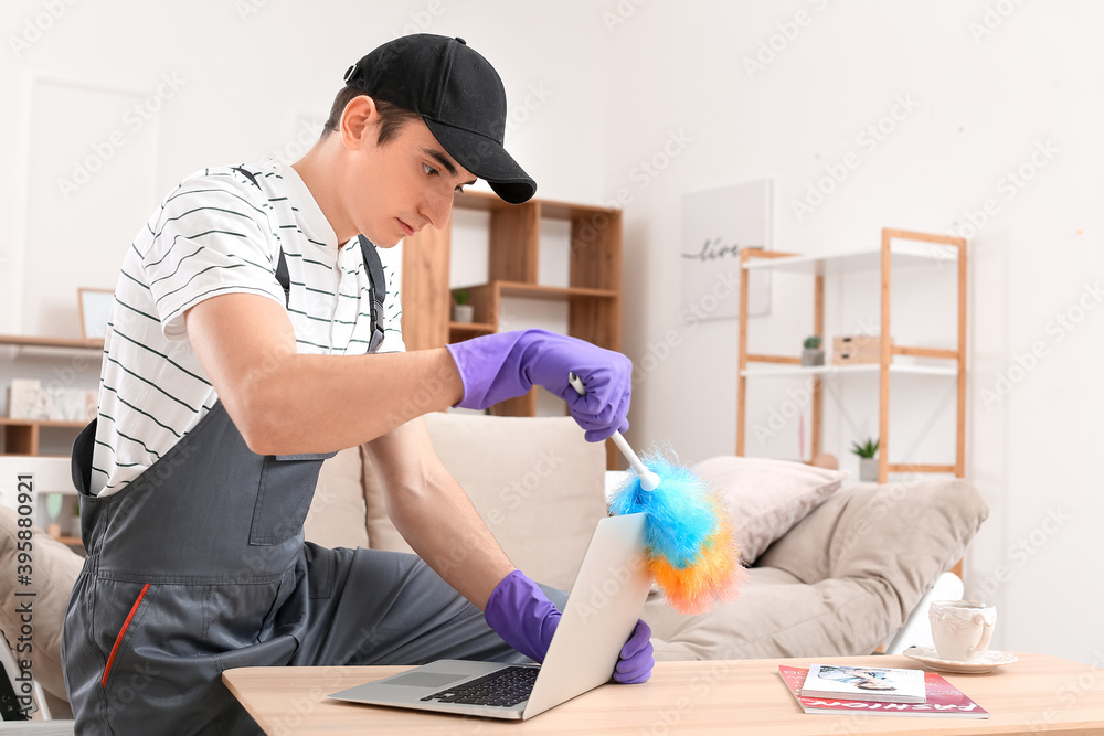 Worker cleaning laptop at home