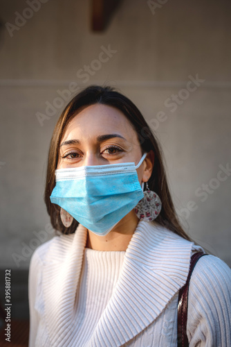 Vertical close up beautiful young woman portrait wearing protective face mask. Pandemic or pollution concept.