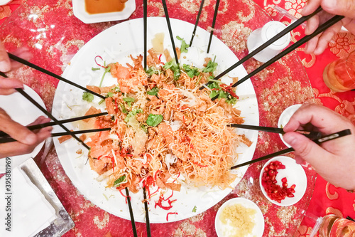 Photography People preparing to toss yusheng or yee sang, a dish consumed during Chinese New