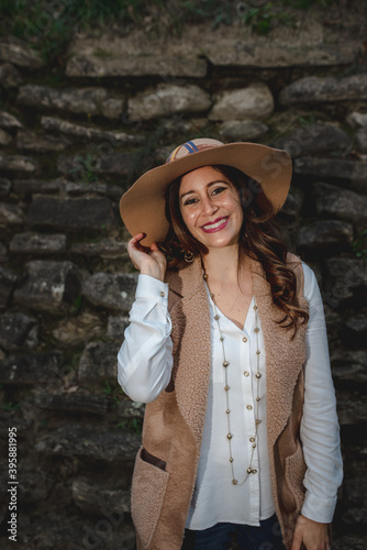 Vertical portrait smiling latin woman wearing a hat. Stylish, elegant cheerful girl outside. © Pintau Studio