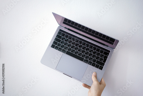 Hand holding a open laptop