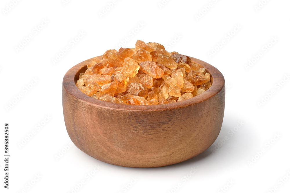 Natural brown  rock sugar made from sugar cane in wooden bowl isolated .on white background.