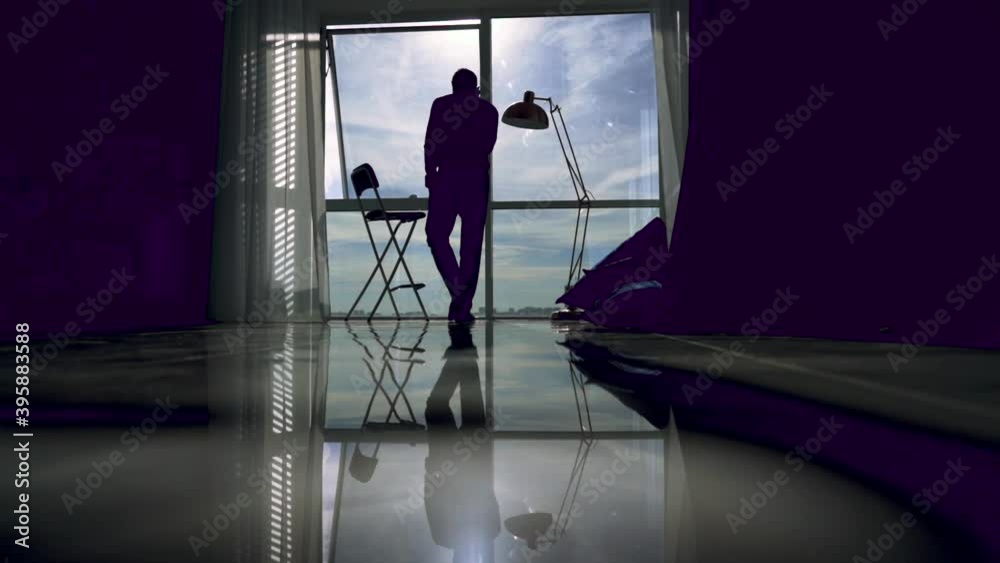 Silhouette of an young man that is talking at phone and walking inside the business building Silhouette of an young man that is talking at phone and walking inside the business building