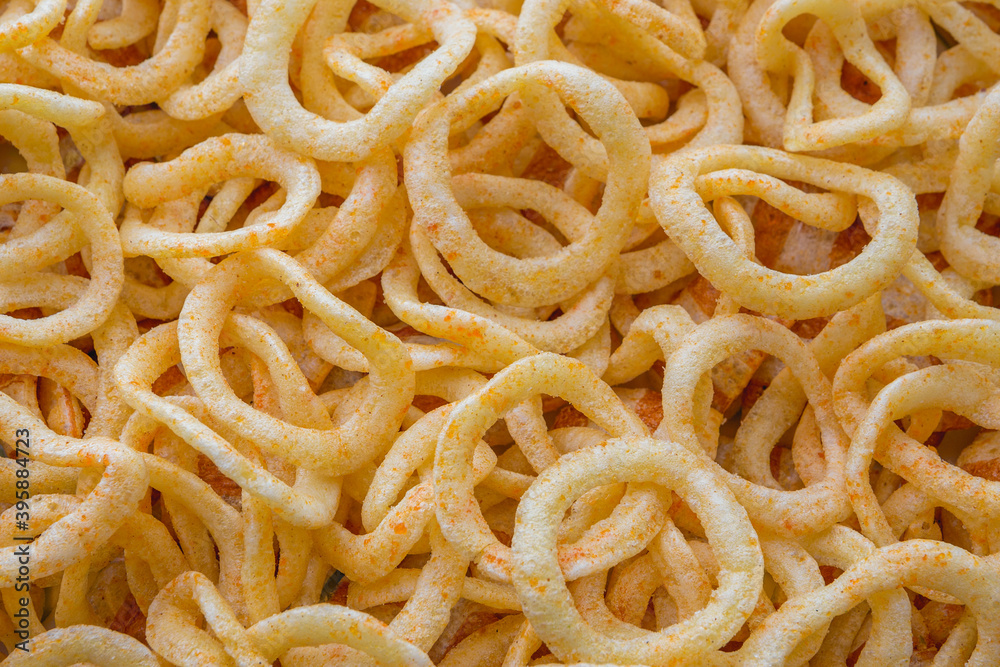 Background food. Round chips with paprika in the form of rings. Studio light. Party snacks. a fresh and spicy snack of potato chips. A bunch of crunchy onion rings.