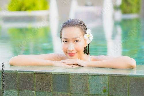 Portrait beautiful young asian woman relax smile around outdoor swimming pool in hotel resort
