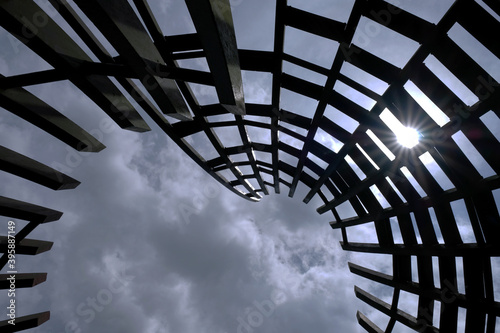 Looking up into the sky in a circular wooden grid structure