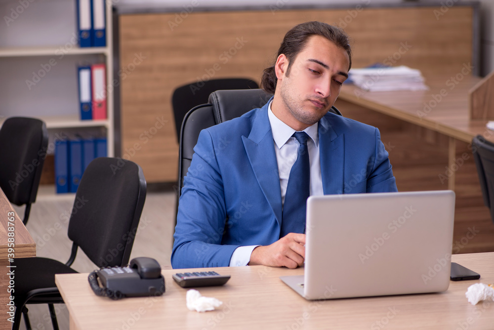 Young sick businessman employee suffering at workplace