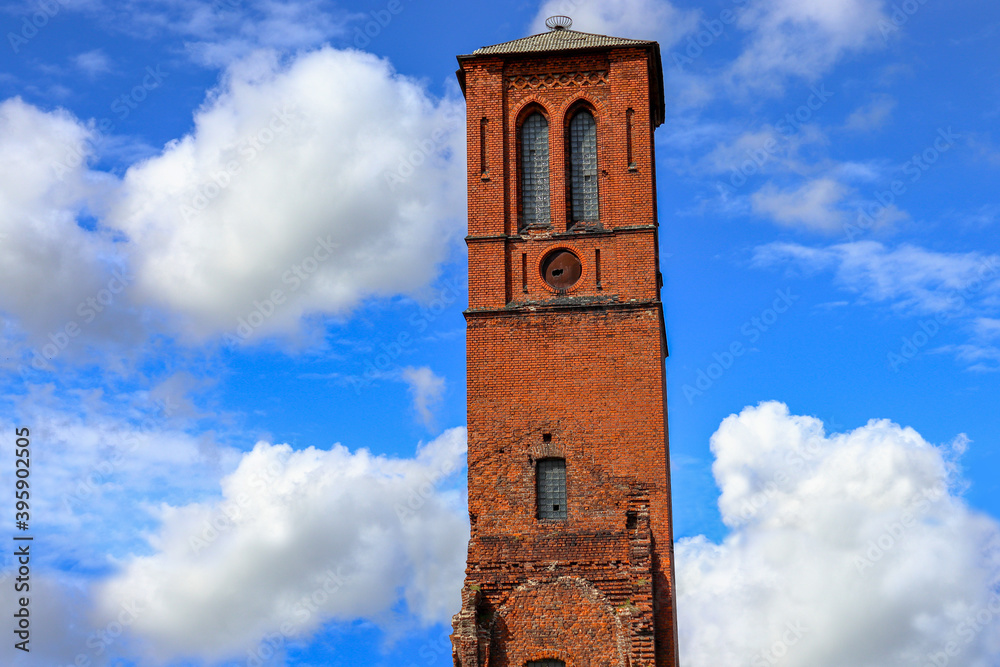 Ruins of the old tower of the reformist church in the city of Sovetsk, against the background of the blue sky and clouds, Kaliningrad region