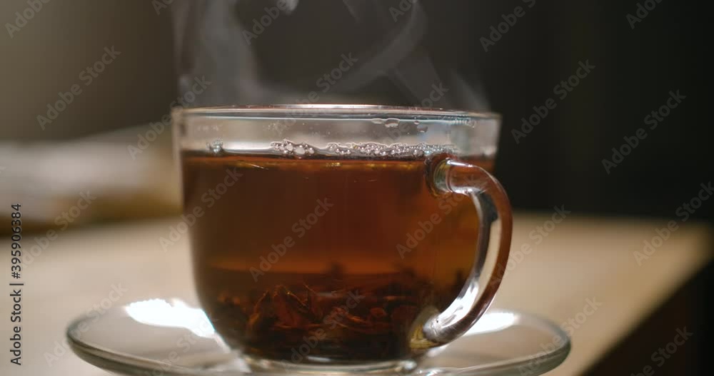 Cup of Freshly Brewed Black Tea on Wooden Table, Escaping Steam, Warm Soft Light, Darker Background. Freshly Brewed Black Tea in Transparent Glass Cup, Escaping Steam. Teatime Ceremony Zen Relaxation. Cup of Freshly Brewed Black Tea on Wooden Table, Escaping Steam, Warm Soft Light, Darker Background. Freshly Brewed Black Tea in Transparent Glass Cup, Escaping Steam. Teatime Ceremony Zen Relaxation.
