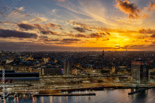 View on the historic city center of Amsterdam with the central train station and river IJ during sunset 