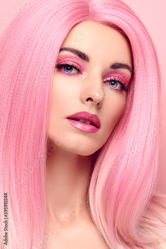 Beauty Fashion woman with Colorful Pink Dyed Hair. Girl with blue eyes, perfect Makeup and Hairstyle. Beautiful smiling model portrait, fashionable pink make up, hair. Skincare concept