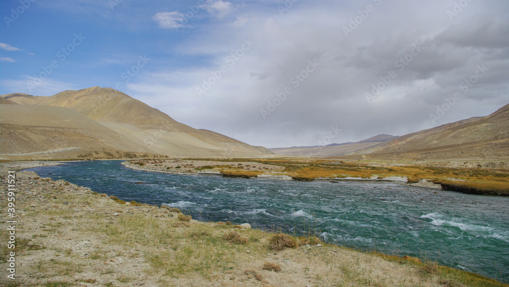 View of the Pamir river in the high desert between Langar and Khargush pass in Gorno-Badakshan, the Pamir mountain region of Tajikistan bordering Afghanistan View of the Pamir river in the high desert between Langar and Khargush pass in Gorno-Badakshan, the Pamir mountain region of Tajikistan bordering Afghanistan