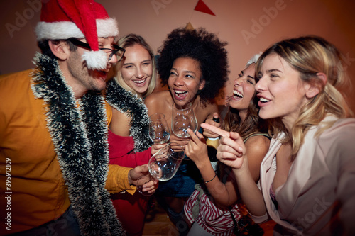 group of female friends at new year party with one male friend, laughing