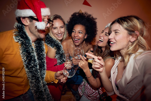 Canvas Print group of female friends at new year party with one male friend, laughing