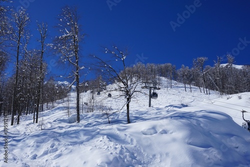 Beautiful winter landscape in the mountainous area, ski slopes, cable car.