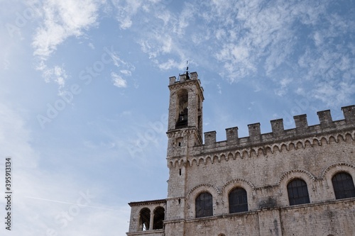 An ancient bell tower of a medieval building with battlements and architectural decorations (Gubbio, Umbria, Italy)