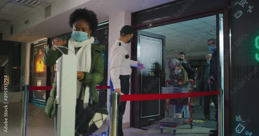 Diverse crowd walking past guard with thermometer and disinfecting hands in mall