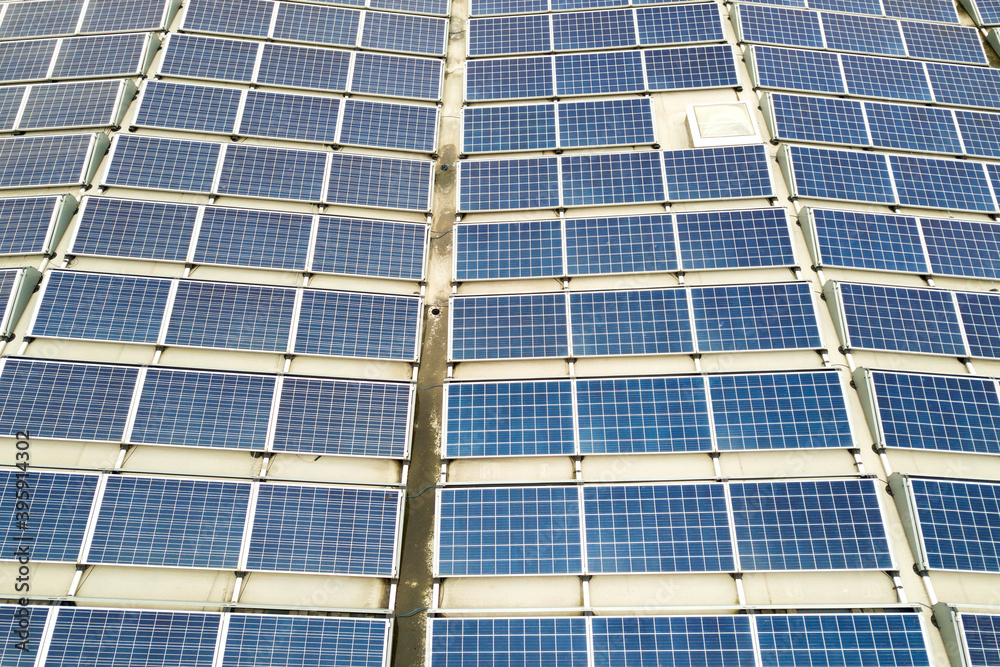 Aerial view of solar power plant with blue photovoltaic panels mounted of industrial building roof. Aerial view of solar power plant with blue photovoltaic panels mounted of industrial building roof.