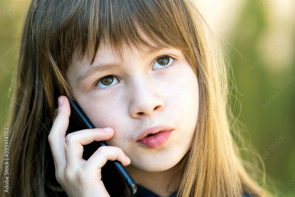 Portrait of pretty child girl with long hair talking on cell phone. Little female kid communicating using smartphone. Children communication concept. Portrait of pretty child girl with long hair talking on cell phone. Little female kid communicating using smartphone. Children communication concept.