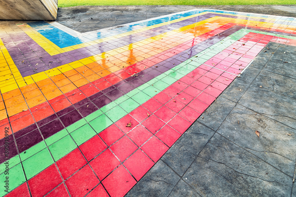 Multicolored sidewalk. Close up of a street with colored tiles in a park.