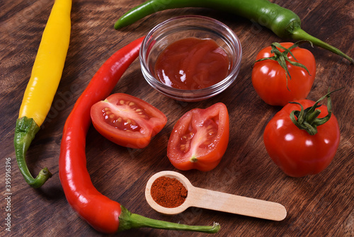 Red and yellow chilli paprika with garlic and cherry tomato on wooden background